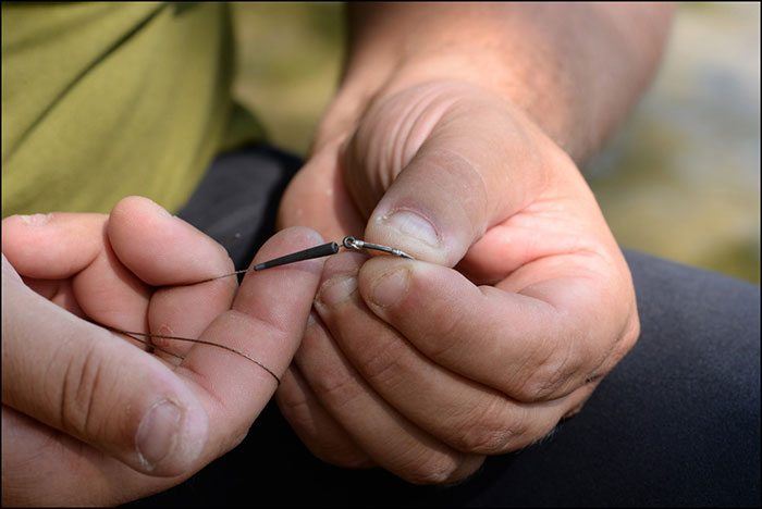 Stap 7: Schuif de Tungsten Line Aligner op de onderlijn. Maak het geheel even nat zodat de Line Aligner makkelijk over het haakoog glijdt, houd hierbij de onderlijn strak.